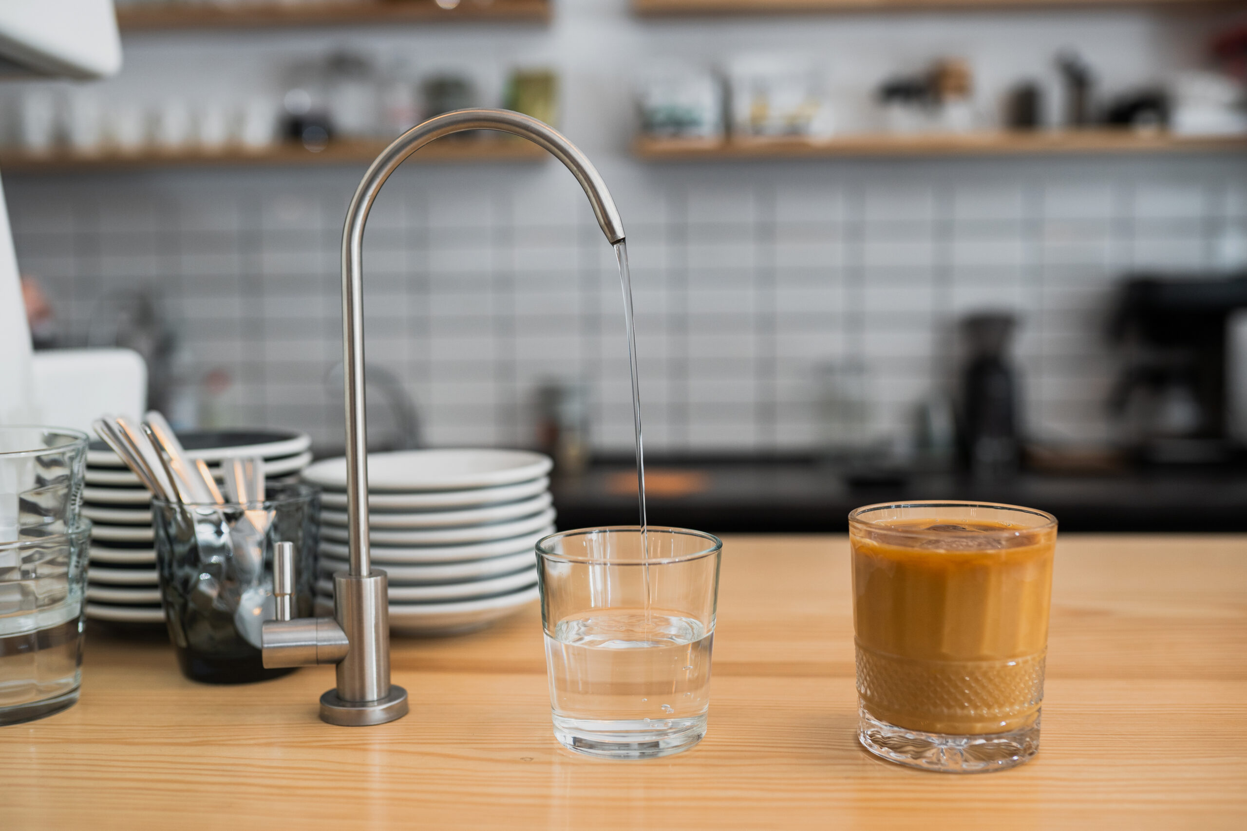 water is pouring from a tap into a glass